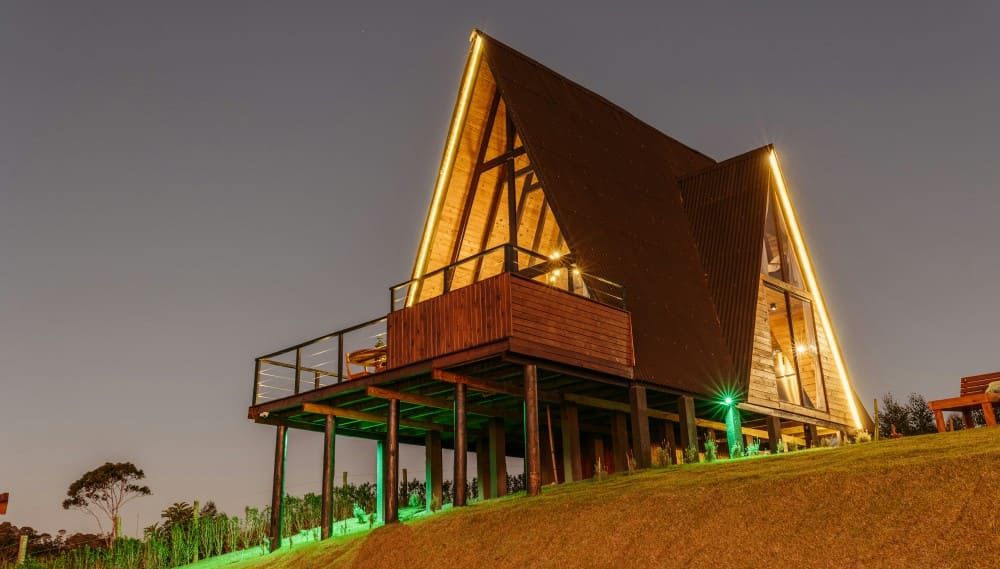 Présentation d'une maison sur pilotis sur un terrain en pente avec des pilotis en bois